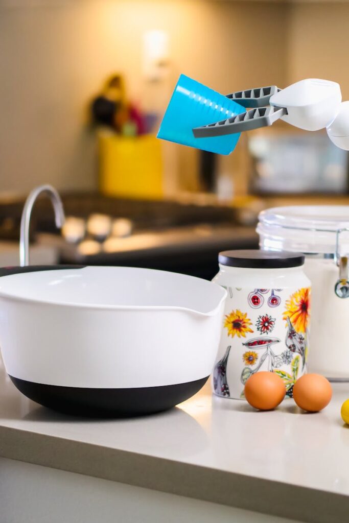 A robotic arm assists with mixing ingredients in a modern kitchen, showcasing advanced home technology.